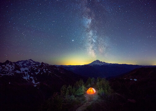 A tent is under the Milky Way on the top of a mountain, Washington, US
