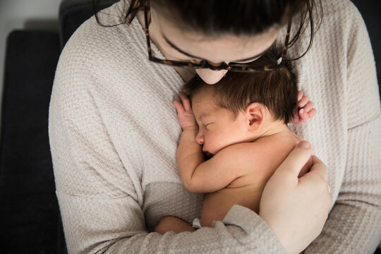 Close Overhead View of Millennial Hipster Mother Snuggling Newborn Son