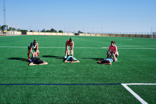 group of young women practice stretching after their training - Powered by Adobe