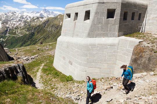 Hikers pass fortified army bunker, Furka Pass, Valais, Switzerland