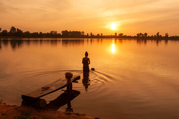 SRA SRANG,ANGKOR PARK, SIEM REAP, CAMBODIA - 15 May 2011: Local lady washes clothes in ancient angkorian bathing pool.