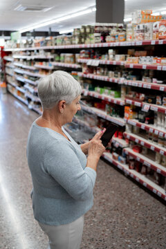 Caucasian elderly woman with white hair  shopping in supermarket