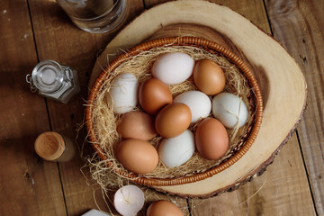 A lot of eggs put in the basket and place on the wooden table..