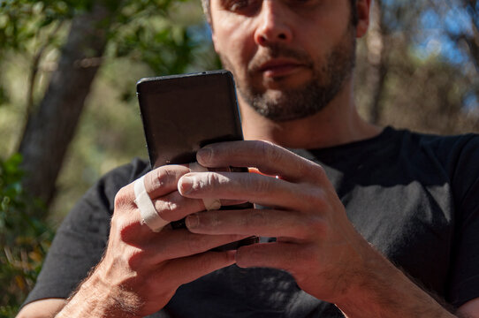Details of the fingers of a climber that consult the mobile.