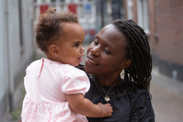 A black mother tries to calm her upset baby daughter