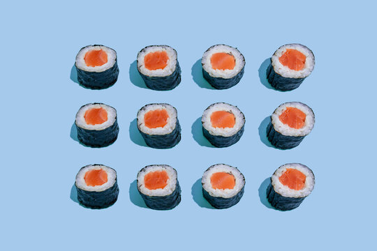 Salmond sushi makis pattern on blue background with shadows