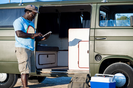 african american man typing on the tablet in a camping