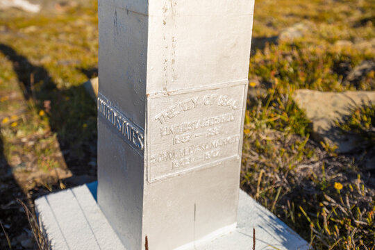 Base of international border marker on mountain ridge.