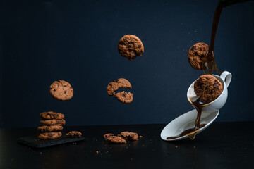 Horizontal image of flying cookies falling on a cup of coffee