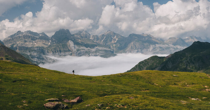 Young woman hiking through Pyrenees with Mount Aspe in the background.