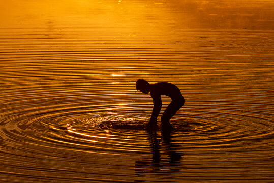 SRA SRANG,ANGKOR PARK, SIEM REAP, CAMBODIA - 11 August 2013: Guy washes clothes in ancient angkorian bathing pool.
