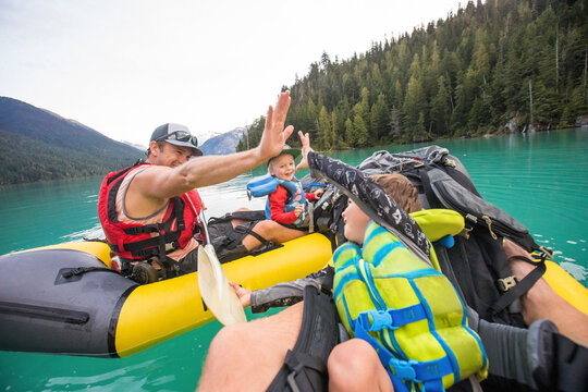 Paddlers high-five during a father son paddling trip