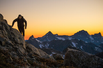 Hiker navigates a mountain route using headlamp after sunset.