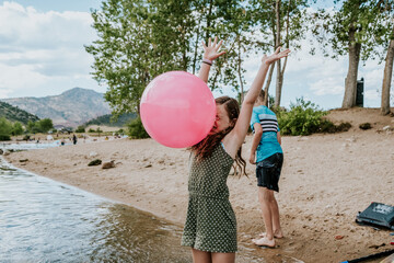 Young girl getting hit in the face with a large ball on a summer day