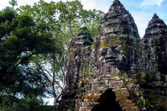 Angkor Archaeological Park, Siem Reap, Cambodia. Close up of Buddha's face on north gate of Angkor Thom surrounded by trees.