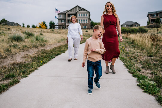 Smiling boy walking with mother and grandmother outside