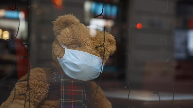 Lonely christmas teddy bear wears medical face mask