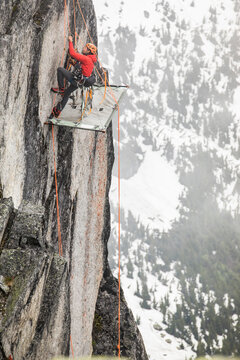 Rock climber uses prusik to ascend cliff above portaledge.