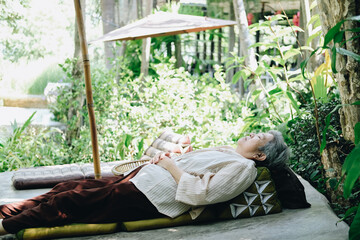 Naklejka na ściany i meble old asian elderly senior elder woman sleeping in garden
