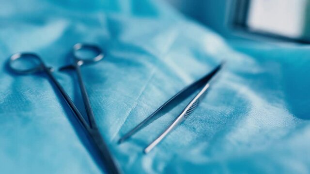 surgical instruments tweezers and clamps on a blue background, macro videography.
