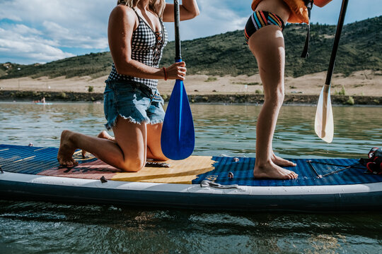 portrait of a woman and young girl on a paddle board on a sunny day