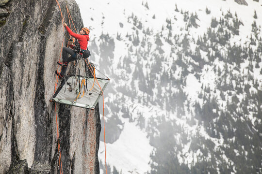 Rock climber uses prusik to ascend cliff above portaledge.