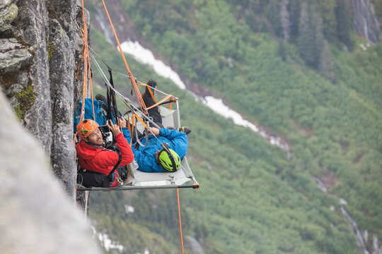Portrait of rock climbers using portaledge during climbing trip.
