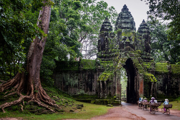 Angkor Archaeological Park, Siem Reap, Cambodia. Locals cycle home through north gate of Angkor Thom.