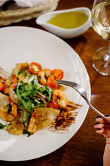 Fresh salad plate with shrimp, tomato and mixed greens on wooden background close up. Healthy food. Clean eating.