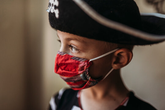 Lifestyle portrait of young boy dressed as pirate with face covering