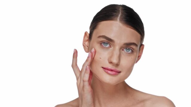 Young adult woman touching face with hands while posing isolated on white