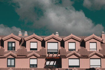 Row of terraced houses in a nice neighborhood under a dramatic sky.