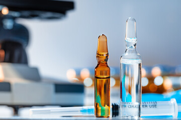 Medical vial with medication near microscope photo