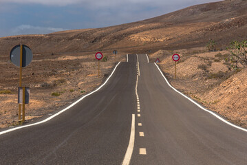 Winding road through the dunes of Corralejo desert with volcano in the background, in Fuerteventura, Canary Islands, Spain