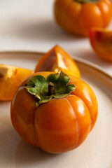 Fresh bright orange autumn persimmon on white background