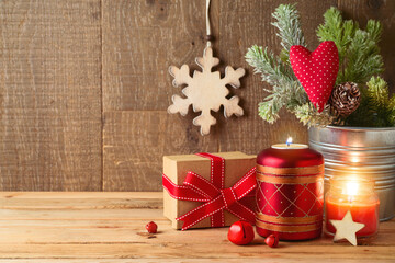 Christmas holiday background with fir tree branches, gift box and candle decor on wooden table. Winter greeting card.