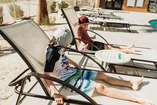 Close up view of young brothers in pool chairs laughing together