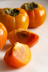 Fresh bright orange autumn persimmon on white background
