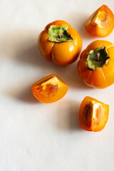 Fresh bright orange autumn persimmon on white background