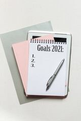 goal 2021 Top view flat lay of desktop and notepads  writing down goals and plans. 2021 New Year's goal, plan,action text on notepad with office accessories. Business motivation, inspiration concept.