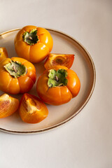 Fresh bright orange autumn persimmon on white background