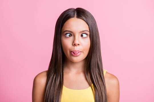 Photo of cheerful funny girl rolled tongue make eyes look at each other isolated pink color background