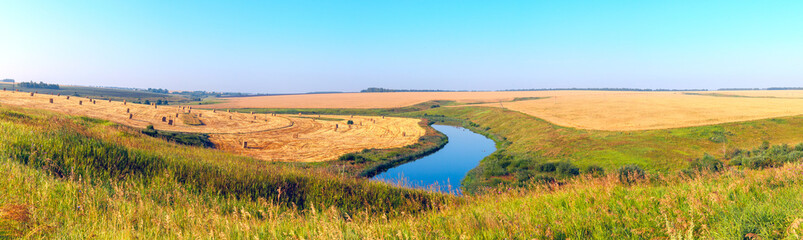 Summer panoramic landscape with river and golden fields