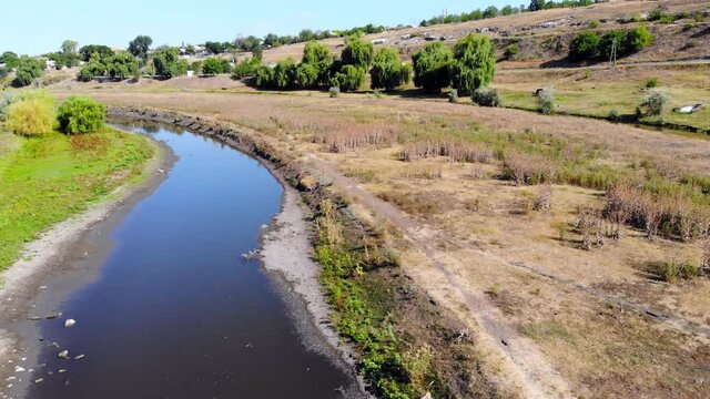 Clear lake in the meadow of a village in Moldova. Aerial drone view. Sunny day