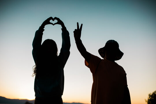 Love and Peace Sign Silhouettes with Colorful Sky - Young People