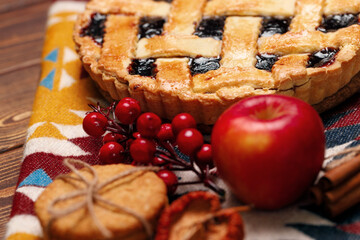 Tart pie with red apple and cinnamon on tablecloth
