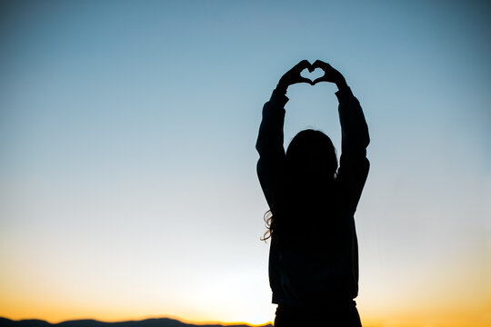 Hands form a Heart for Love Silhouette with Sunset or Sunrise