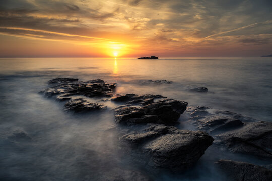 Beautiful sunset on the coast with the waves passing over the rocks