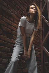 Young woman model posing over red brick wall background