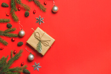 Christmas composition. Frame made of christmas gifts, pine branches, isolated on red background. Flat lay, top view